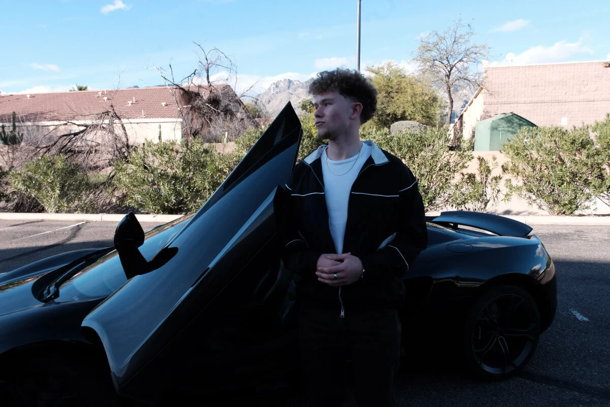 Ross in front of a car